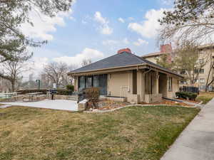 View of property exterior with a patio area and a lawn