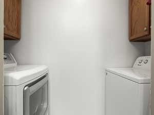 Laundry room featuring cabinets and washing machine and clothes dryer