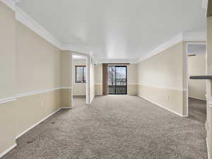 Carpeted spare room featuring a wall mounted air conditioner and ornamental molding