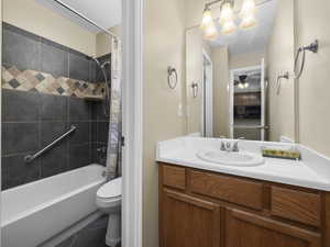 Full bathroom with shower / bath combination with curtain, tile patterned floors, toilet, and vanity