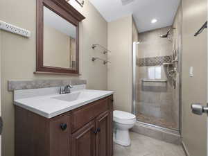 Bathroom featuring vanity, an enclosed shower, tile patterned floors, and toilet