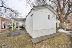 Back of property featuring a yard with mature trees