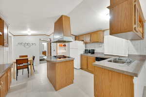 Kitchen featuring sink, appliances, ventilation hood, and kitchen peninsula