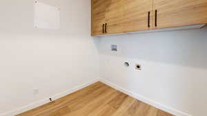 Laundry area featuring cabinets, hardwood / wood-style flooring, hookup for a washing machine, and electric dryer hookup