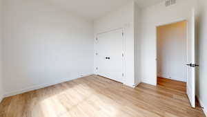 Unfurnished bedroom featuring light wood-type flooring and a closet