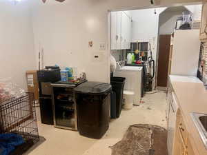 Kitchen with washer and clothes dryer, light brown cabinetry, and sink