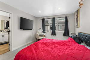 Bedroom with ensuite bathroom and light carpet