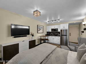 Bedroom featuring hardwood / wood-style floors and stainless steel fridge