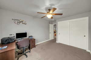 Carpeted office space with ceiling fan