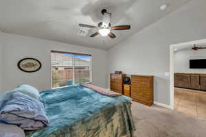 Bedroom featuring light carpet, lofted ceiling, and ceiling fan