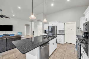 Kitchen featuring white cabinetry, a kitchen island with sink, stainless steel appliances, sink, and pendant lighting