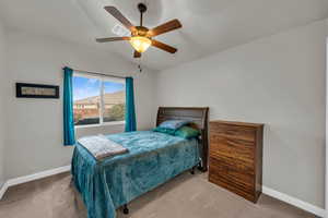 Bedroom featuring vaulted ceiling, ceiling fan, and carpet flooring