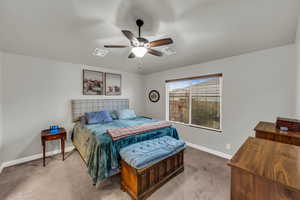 Carpeted bedroom featuring ceiling fan