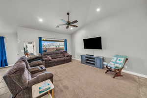 Carpeted living room featuring vaulted ceiling and ceiling fan