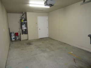 Garage featuring a garage door opener and water heater