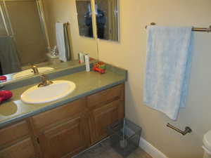 Bathroom featuring tile patterned flooring, vanity, and toilet