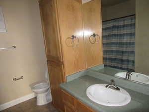 Bathroom featuring tile patterned flooring, vanity, toilet, and walk in shower