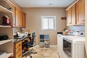 Clothes washing area with cabinets and separate washer and dryer