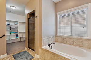 Bathroom featuring tile patterned flooring and shower with separate bathtub