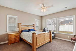 Carpeted bedroom featuring ceiling fan