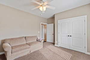 Living room featuring carpet flooring and ceiling fan