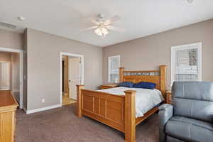 Carpeted bedroom featuring ceiling fan