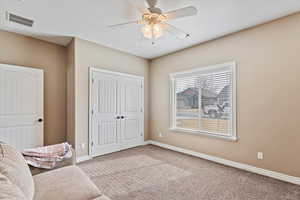 Living area featuring carpet and ceiling fan