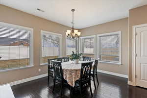 Dining room with a chandelier and dark hardwood / wood-style flooring