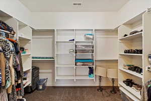 Walk in closet featuring dark carpet