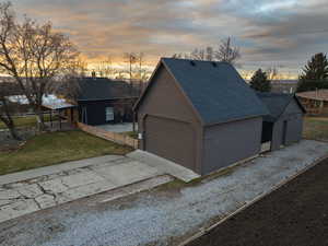 Garage at dusk featuring a lawn