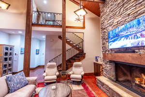 Living room with a fireplace, wooden ceiling, a towering ceiling, and wood-type flooring