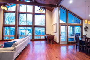 Living room featuring beam ceiling, expansive windows, wooden ceiling, high vaulted ceiling, and hardwood / wood-style floors