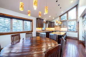 Dining room with vaulted ceiling, dark hardwood / wood-style flooring, and sink