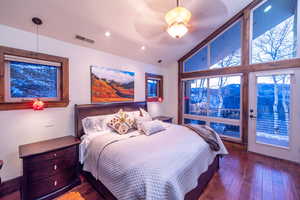 Bedroom featuring lofted ceiling, a mountain view, dark hardwood / wood-style floors, ceiling fan, and access to exterior