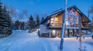 Snow covered rear of property featuring a balcony