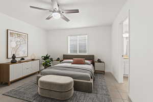 Bedroom with light tile patterned floors, connected bathroom, baseboards, and ceiling fan