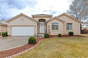 Mediterranean / spanish-style home with a front yard and a garage