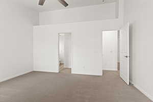Unfurnished bedroom with carpet flooring, baseboards, a ceiling fan, and ensuite bathroom
