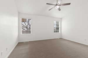 Empty room featuring healthy amount of natural light, baseboards, a ceiling fan, and carpet floors