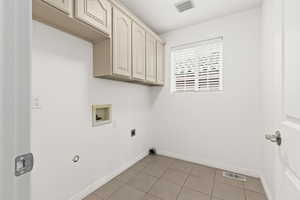 Clothes washing area featuring hookup for a washing machine, cabinet space, baseboards, electric dryer hookup, and light tile patterned flooring