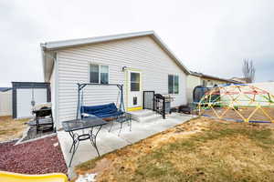 Back of house with a patio, a trampoline, and a lawn