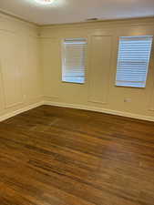 Spare room with dark hardwood / wood-style flooring and a textured ceiling