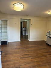 Unfurnished room with ornamental molding, a textured ceiling, and dark hardwood / wood-style flooring