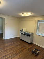 Interior space with ornamental molding, dark hardwood / wood-style floors, and a textured ceiling