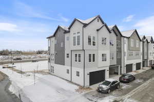 View of snowy exterior featuring a garage