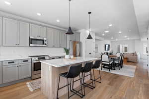 Kitchen featuring stainless steel appliances, a kitchen island, and gray cabinetry