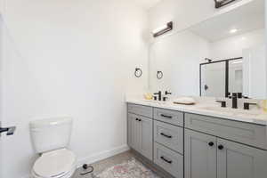 Bathroom with vanity, toilet, and a shower with shower door