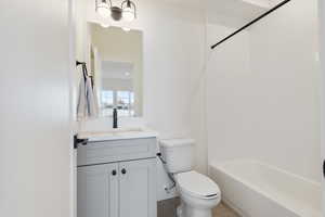 Full bathroom with tile patterned flooring, vanity, tiled shower / bath, and toilet