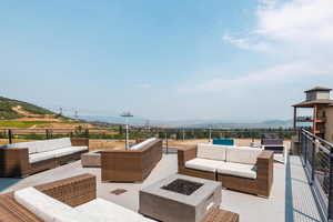 View of patio with a mountain view and an outdoor living space with a fire pit