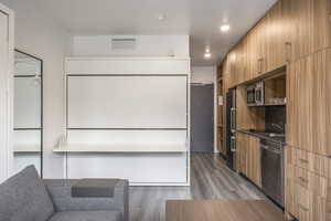 Kitchen with sink, wood-type flooring, and appliances with stainless steel finishes